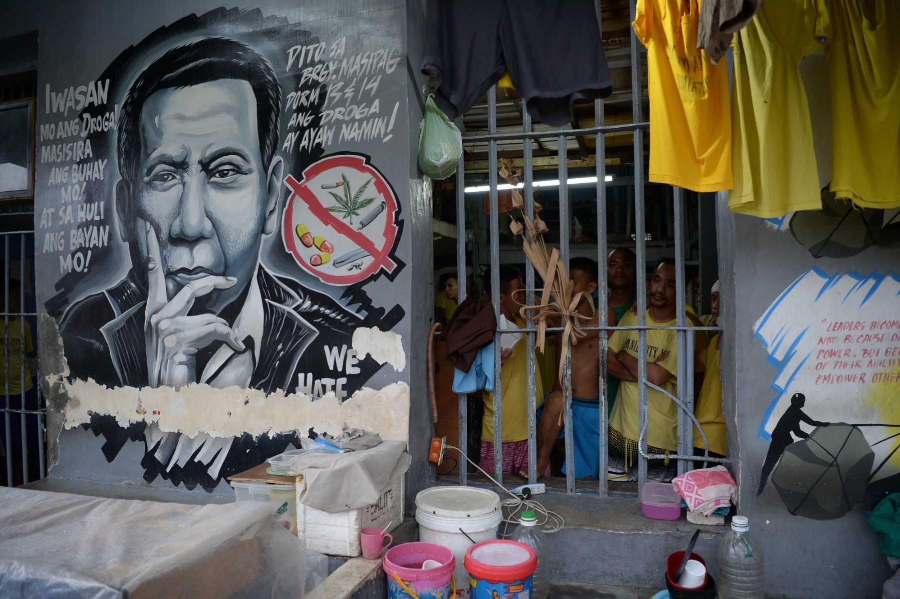 This photo taken on Aug 13, 2018, show inmates standing next to a portrait of Philippine President Rodrigo Duterte inside the city jail in Manila. Photo: AFP 