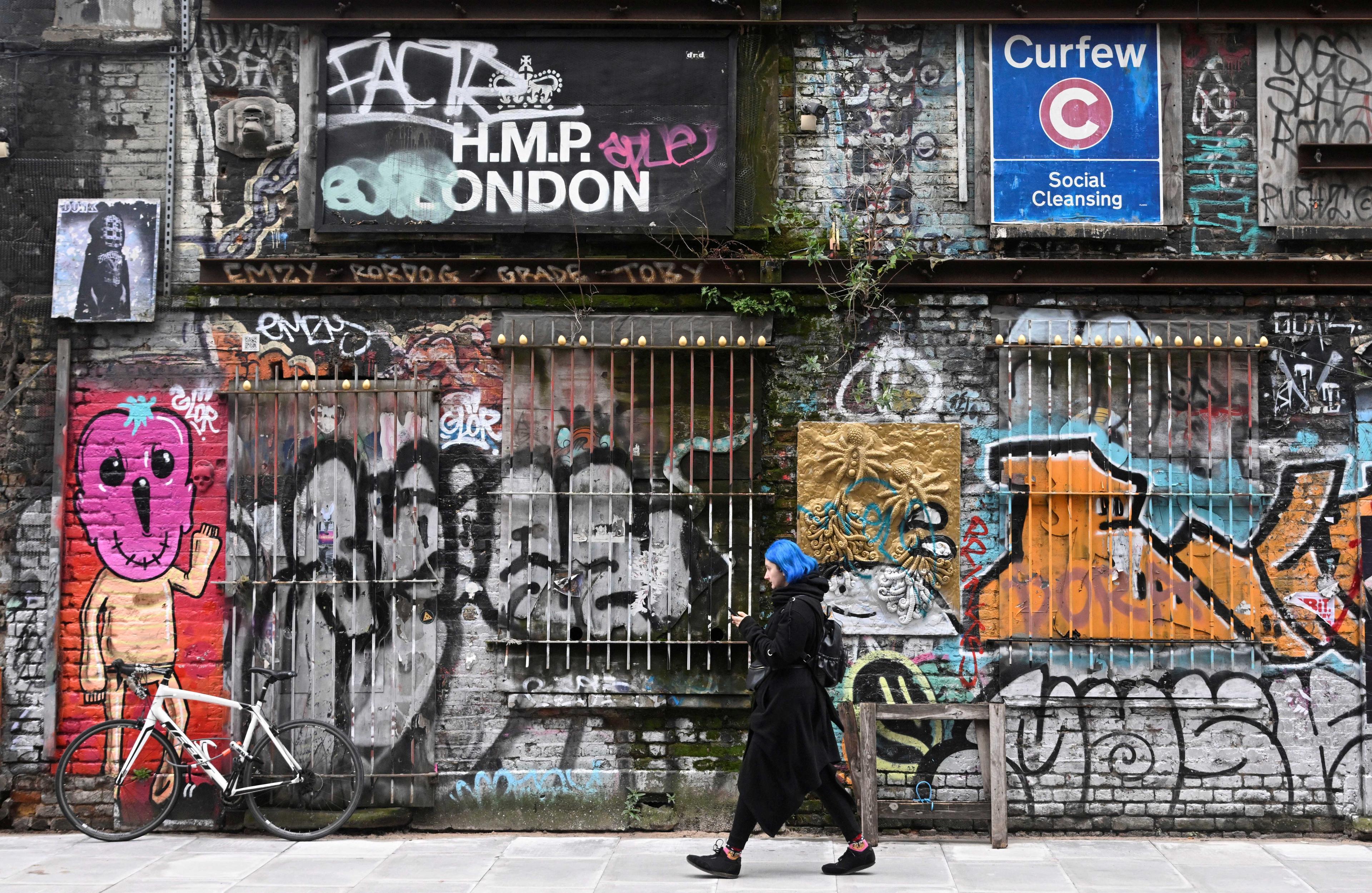 A woman walks past street art and graffiti in London, Britain, March 10. Photo: Reuters
