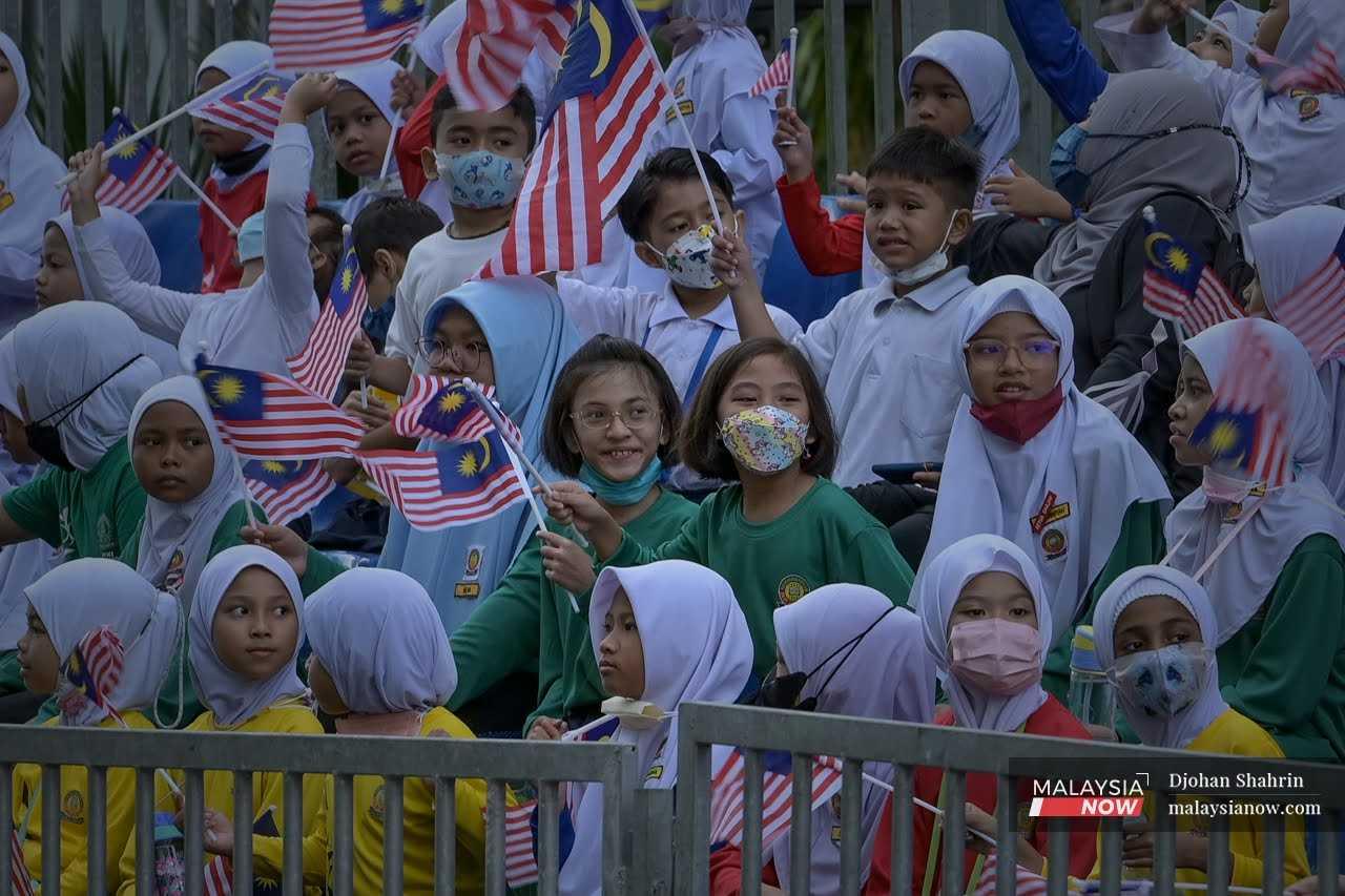Schoolchildren wave the Jalur Gemilang at a rehearsal for the Merdeka Day parade in Kuala Lumpur, Aug 29, 2022. 