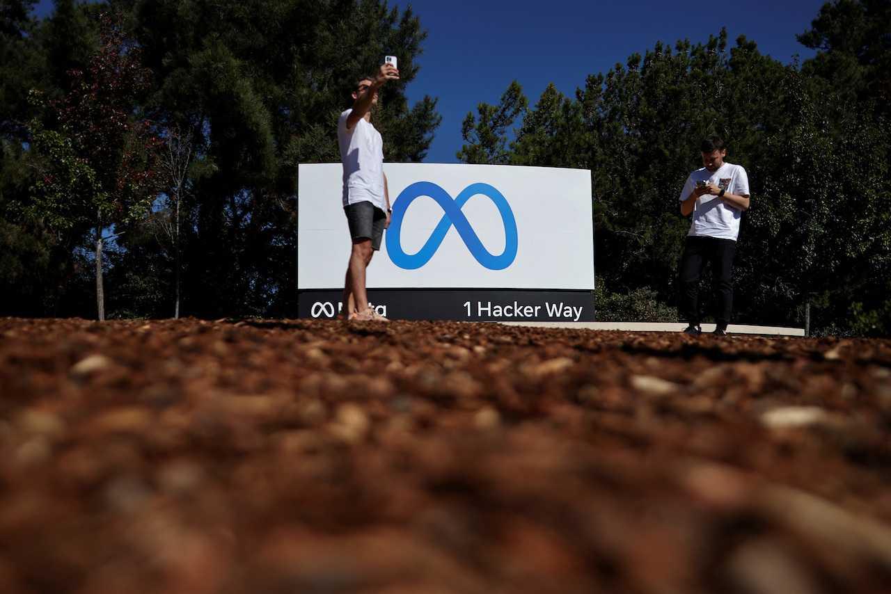 A man takes a selfie in front of a Meta sign at its headquarters in Menlo Park, California, Oct 28, 2021. Photo: Reuters