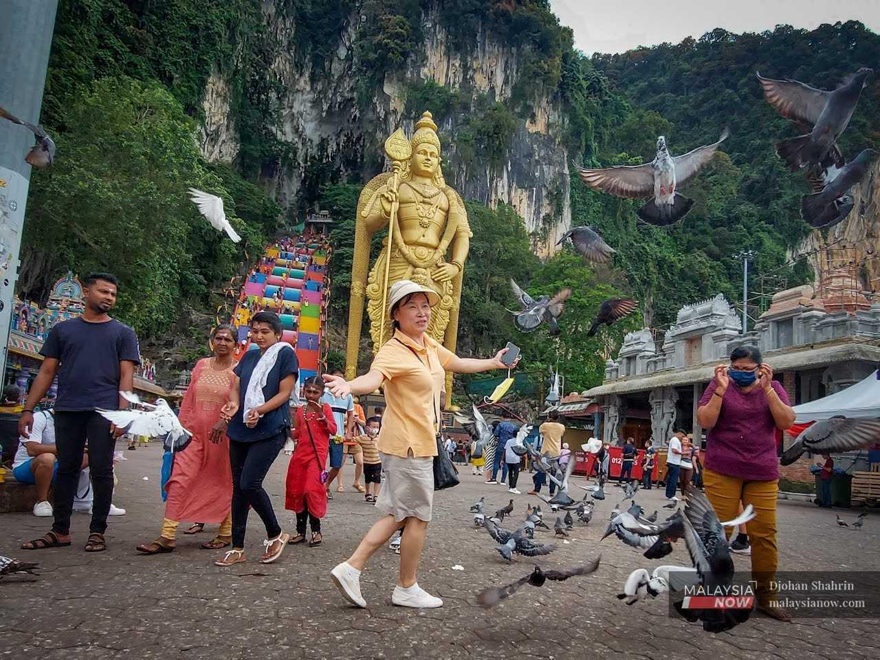 Gelagat seorang pelancong dari Jepun ketika berkunjung di Batu Caves sempena sambutan Hari Thaipusam.
