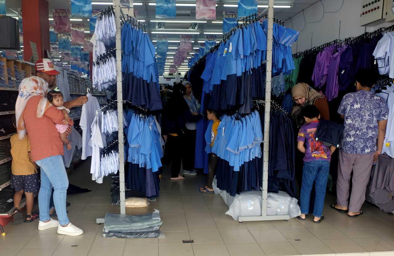 Parents shop for school uniforms ahead of the new school session in Kuantan, March 11. Photo: Bernama