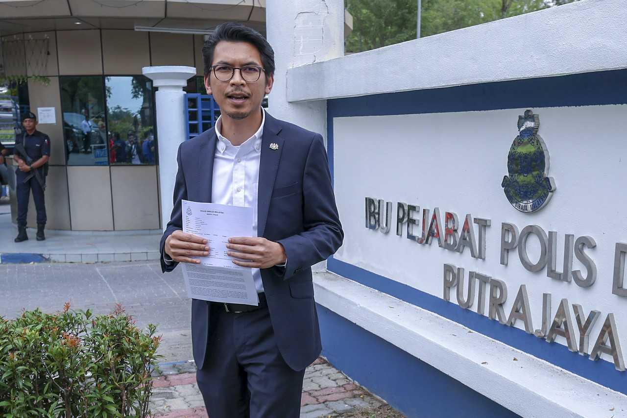 Muhammad Kamil Abdul Munim, the political secretary to the finance minister, holds a copy of the police report lodged against former prime minister Muhyiddin Yassin at the Putrajaya district police headquarters, March 13. Photo: Bernama
