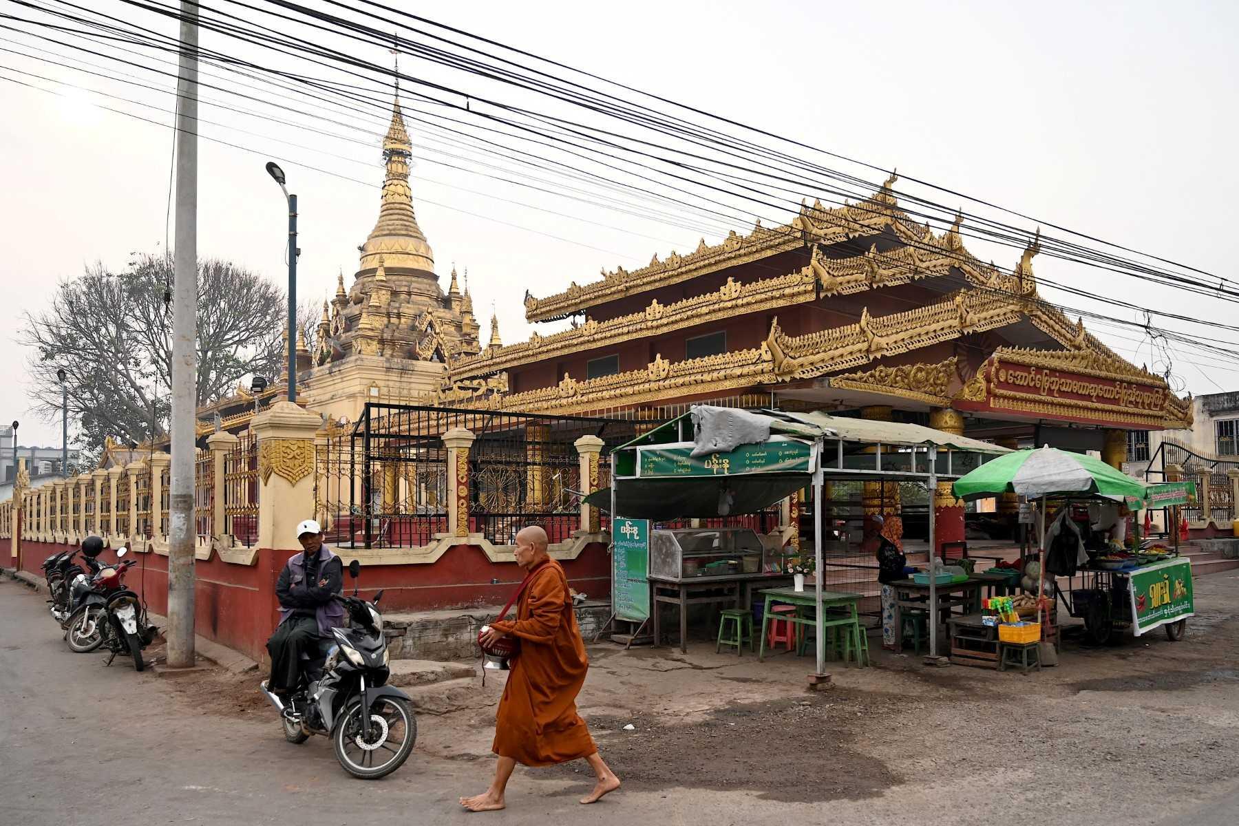 A Buddhist monk walks past a temple in Pyin Oo Lwin Township, Mandalay, on March 11. Photo: AFP