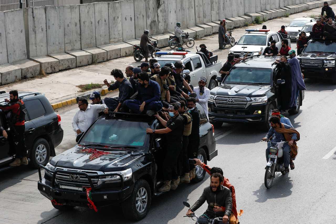 Supporters of former Pakistani prime minister Imran Khan escort his vehicles as Khan travels to appear before the court, in Islamabad, Pakistan, March 18. Photo: Reuters