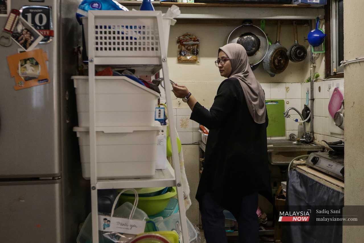 Zaimi's wife in their tiny kitchen, which has barely enough space to move around in. 