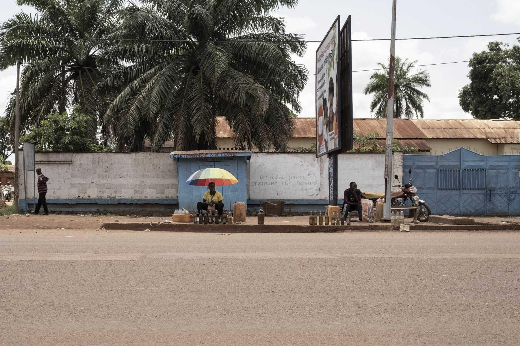 A man sells fuel while sitting next to another vendor on the roadside in Bangui, on Oct 16, 2022. Photo: AFP