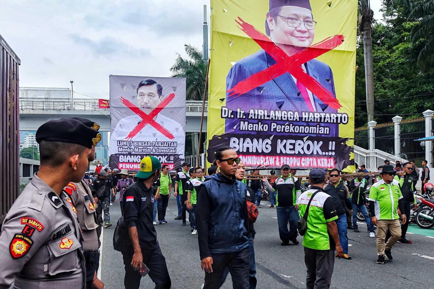 Labourers display banners during a rally in front of parliament building in Jakarta on March 14, rejecting the passage of a new work creation bill. Photo: AFP