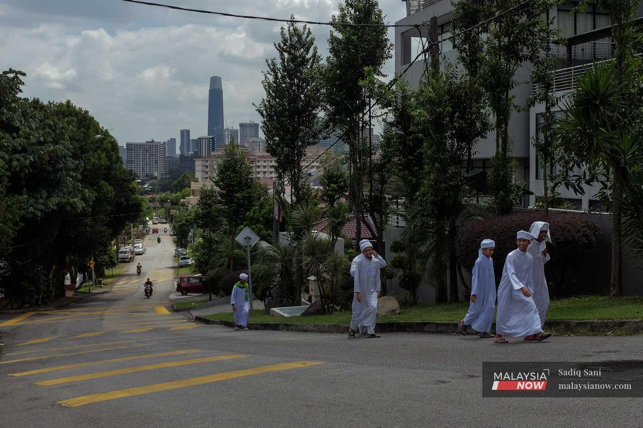 The students walk up the hill along Jalan Keramat Hujung as they make their way to the mosque. 