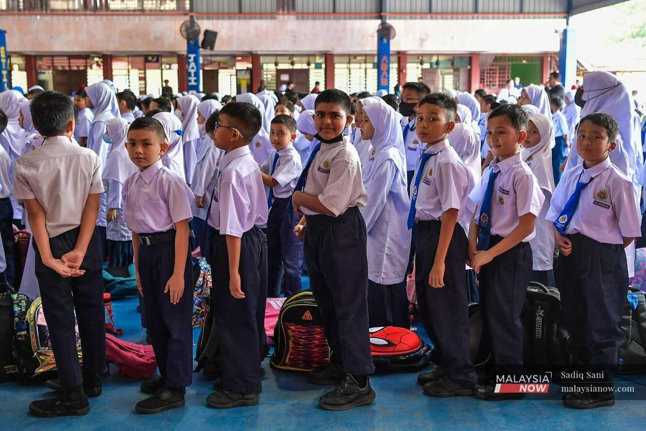 Murid-murid beratur di dewan SK Taman Tasik di Ampang, Kuala Lumpur sebelum memasuki kelas pada hari pertama persekolahan pada 20 Mac.
