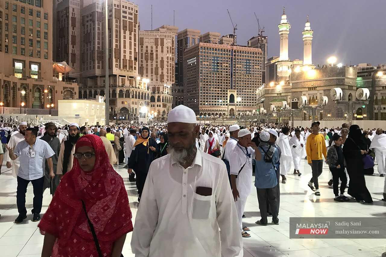 Umat Islam berjalan kaki di hadapan Masjidil Haram di Mekah, Arab Saudi selepas menunaikan solat Maghrib.