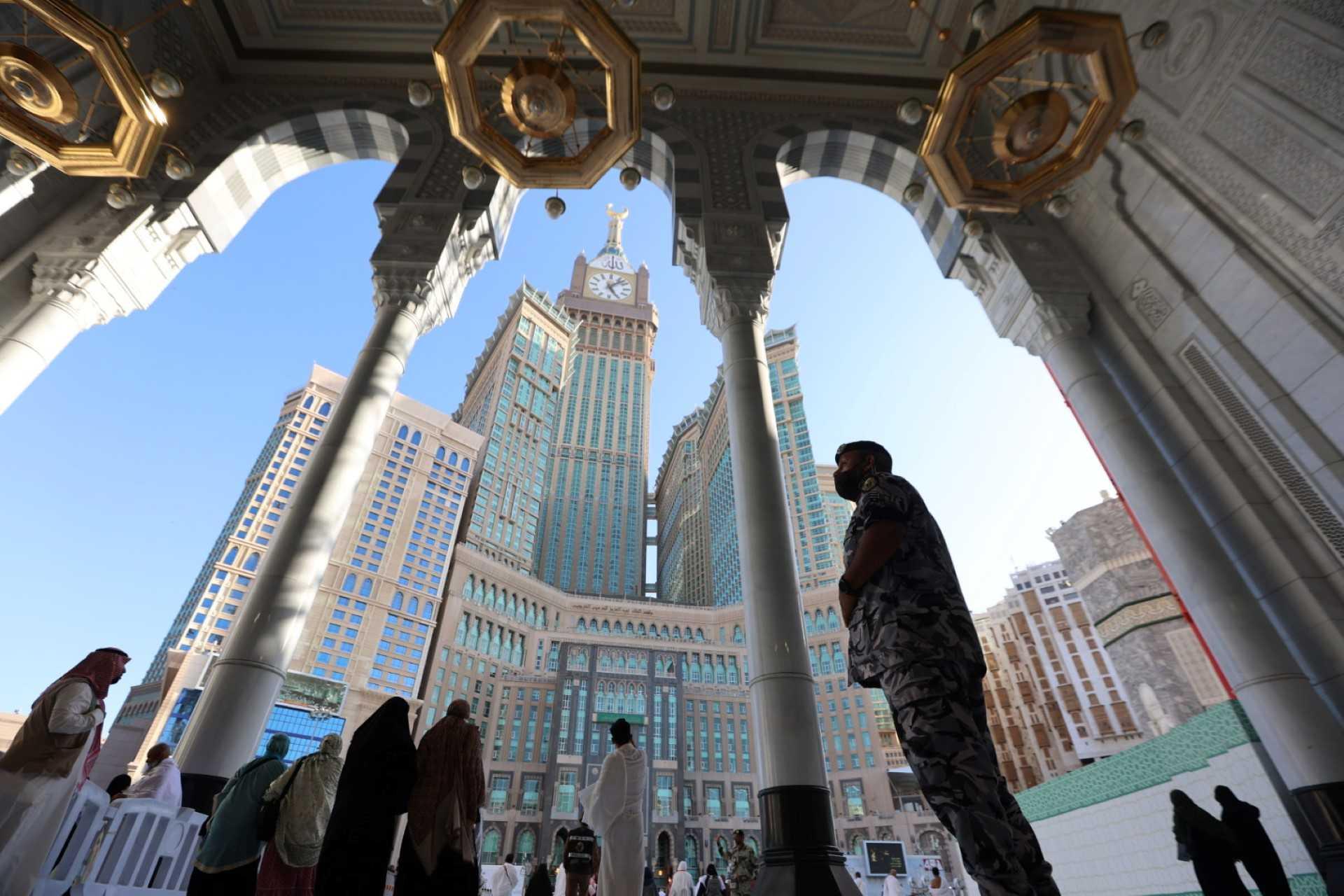 Mecca's Clock Tower is seen in the background as a member of the Saudi security forces stands guard while worshippers pray at the Grand Mosque in the holy city on March 21. Photo: AFP