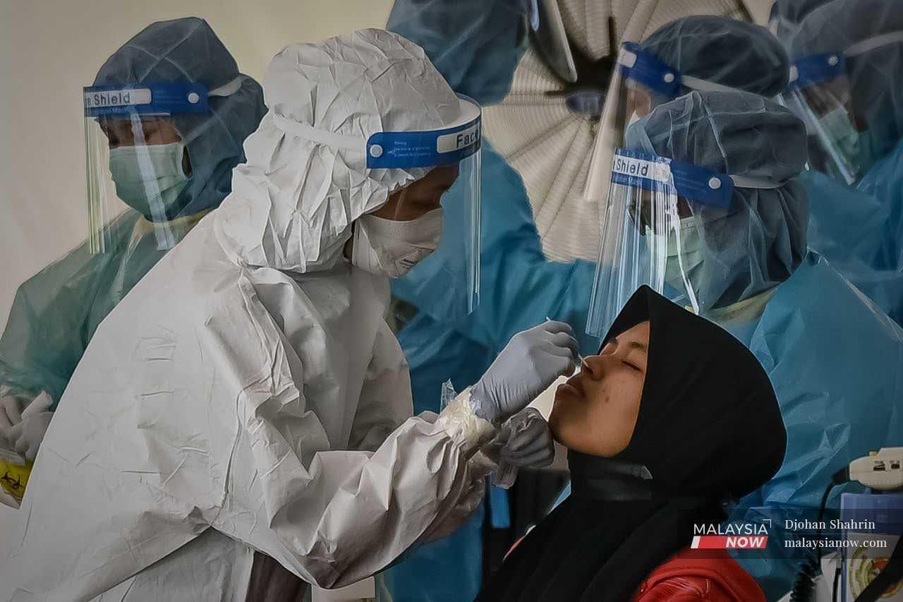 Gambar fail petugas kesihatan mengambil sampel swab bagi ujian saringan Covid-19.