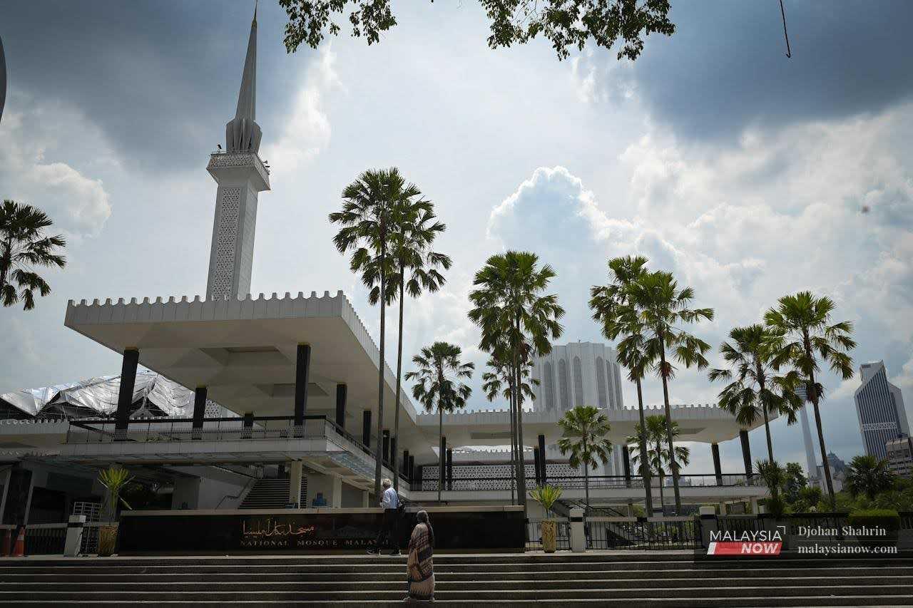 Dua pelancong dari India berjalan di hadapan Masjid Negara ketika mengunjungi kawasan tarikan pelancong di Kuala Lumpur, 18 Mei 2022.