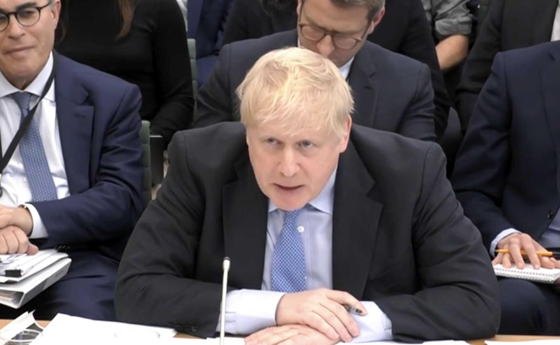 A video grab from footage broadcast by the UK Parliament's Parliamentary Recording Unit shows former British Prime Minister Boris Johnson looking at photographs of him in Downing Street on Nov 13, 2020, as he attends a Parliamentary Privileges Committee hearing, in central London on March 22. Photo: AFP