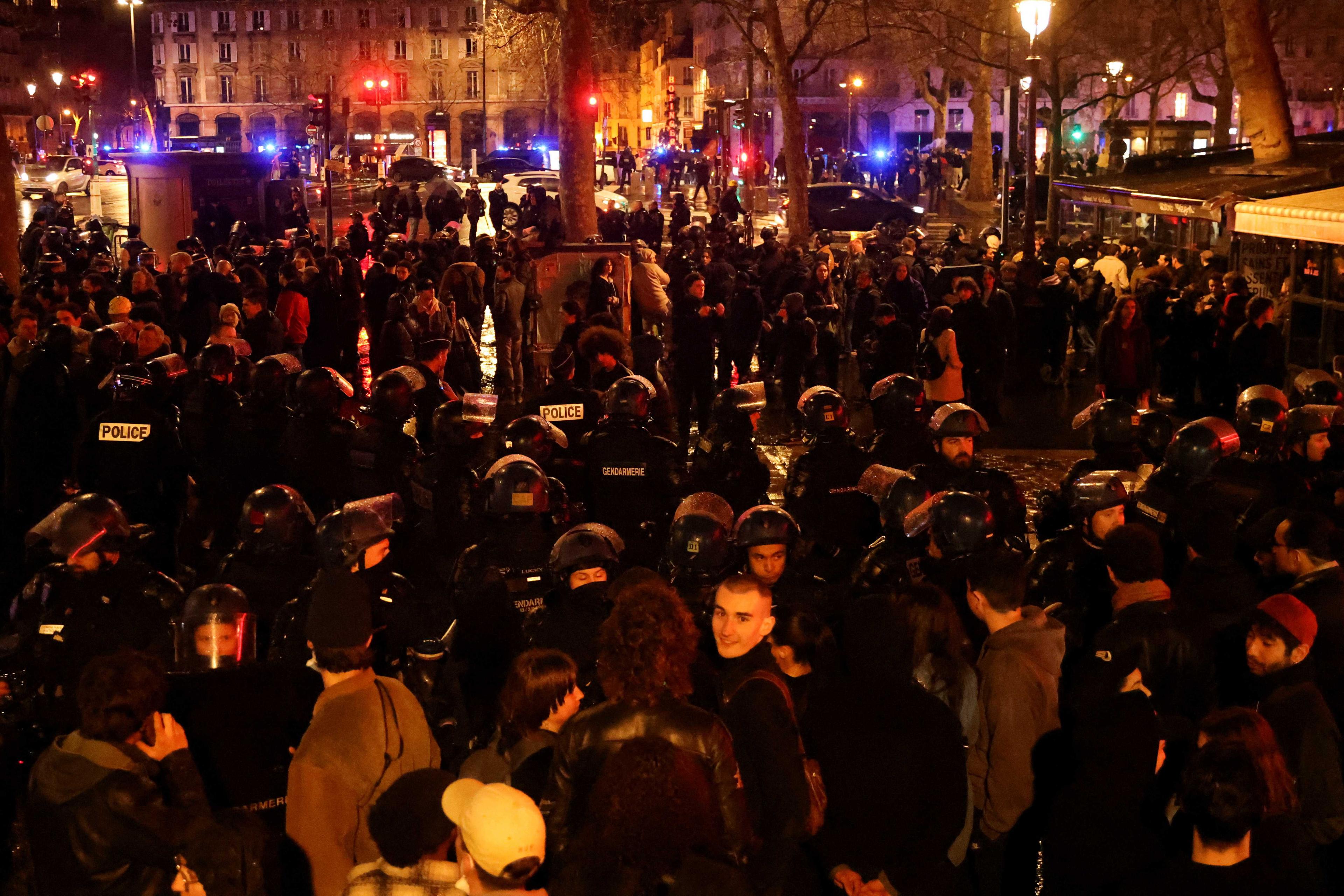 Penunjuk perasaan berdiri di sebelah polis anti-rusuhan semasa demonstrasi jalanan di seluruh negara yang memasuki hari kesembilan bagi membantah pembaharuan skim pencen oleh kerajaan Perancis di Paris, 24 Mac. Gambar: Reuters
