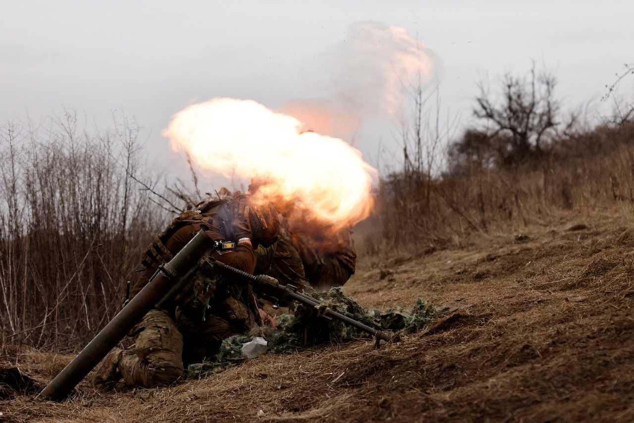 Ukrainian soldiers of the Paratroopers' of 80th brigade take cover as they fire a mortar shell at a frontline position near Bakhmut, amid Russia's attack on Ukraine, in Donetsk region, March 16. Photo: Reuters