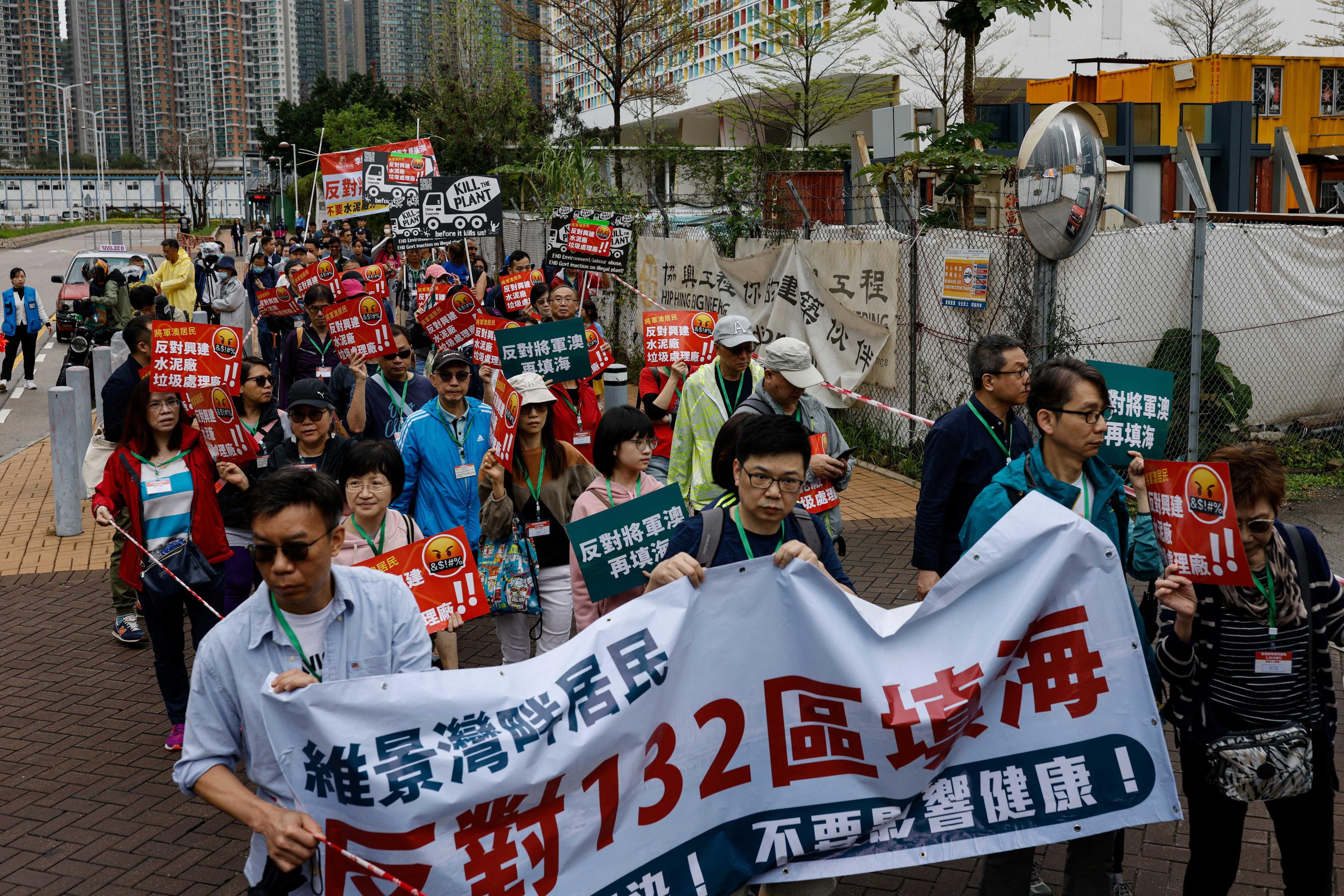Penunjuk perasaan dikehendaki memakai lanyard bernombor di leher mereka ketika perarakan membantah projek tebus guna tanah dan stesen pemindahan sisa pepejal. Ini adalah salah satu tunjuk perasaan pertama yang diluluskan secara rasmi sejak penggubalan undang-undang keselamatan negara secara menyeluruh, di Hong Kong, China 26 Mac. Gambar: Reuters