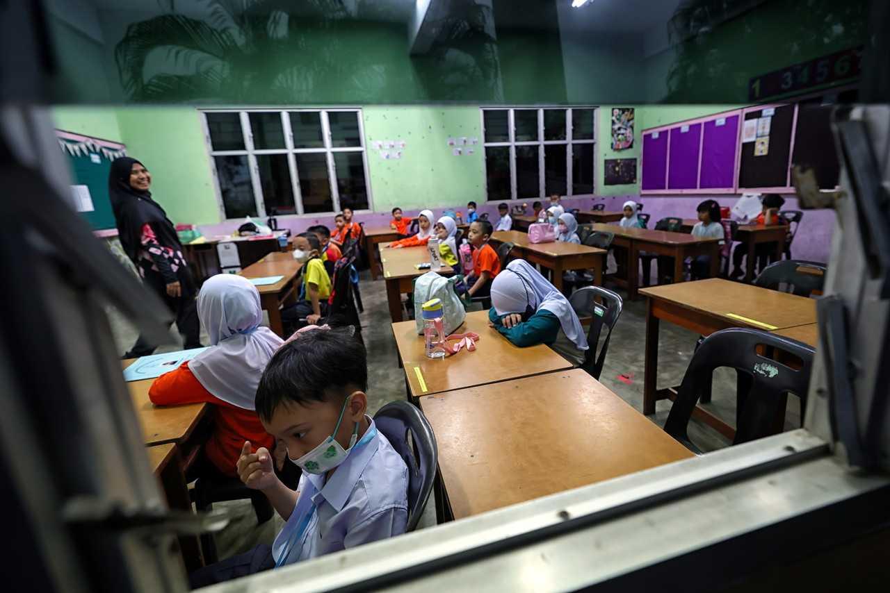 Seorang guru memulakan sesi suai kenal bersama anak muridnya pada hari pertama persekolahan di Sekolah Kebangsaan Petra Jaya, Kuching 20 Mac. Gambar: Bernama