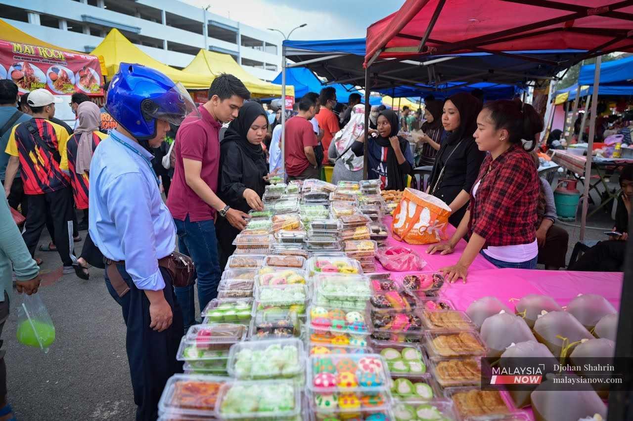 Customers buy kuih from a stall at the Ramadan bazaar in Bandar Baru Ampang, Selangor.

