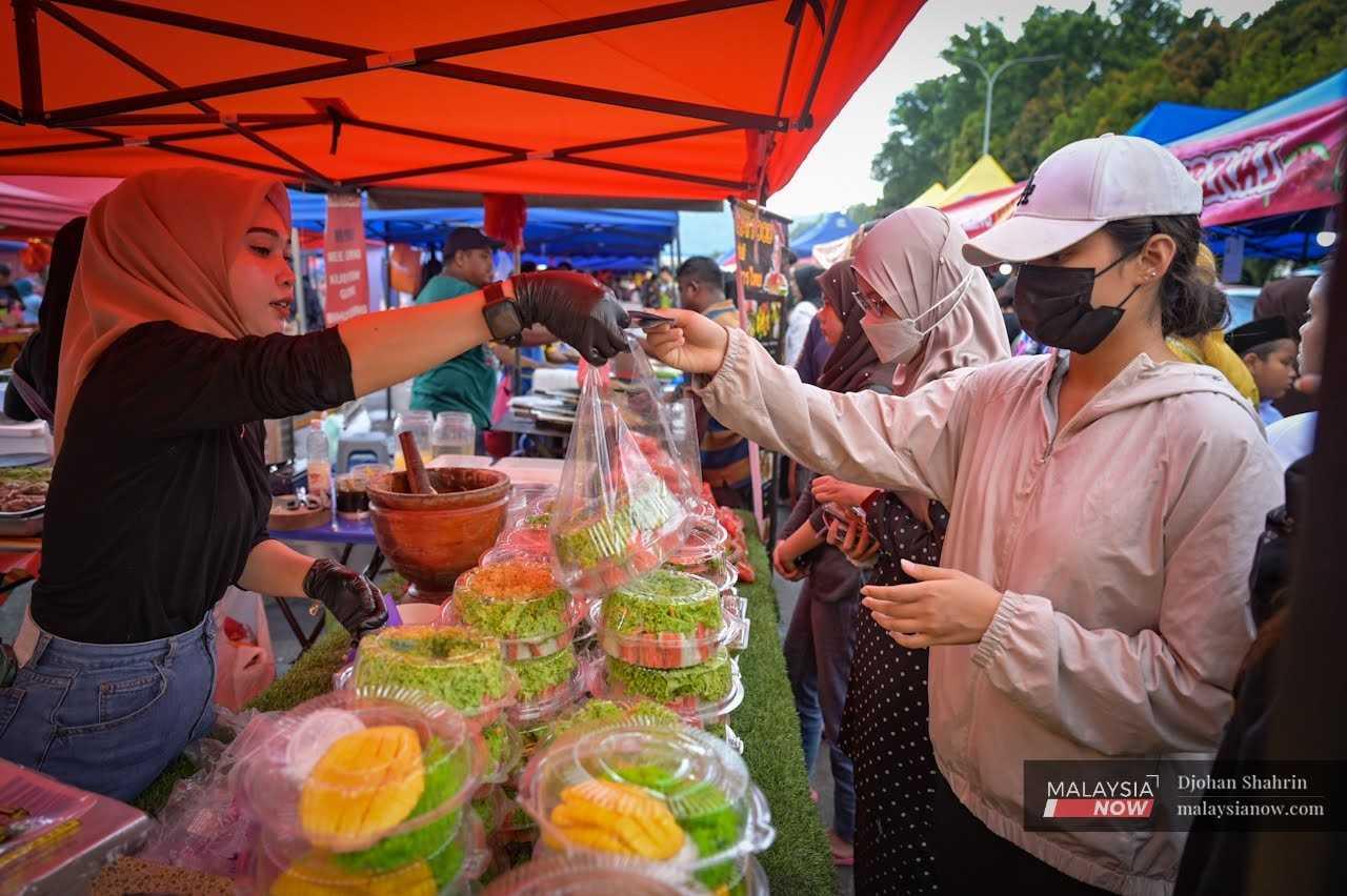 Beberapa pelanggan membeli pulut mangga sebagai juadah berbuka puasa semasa berkunjung di Bazar Ramadan Bandar Baru Ampang, 27 Mac.