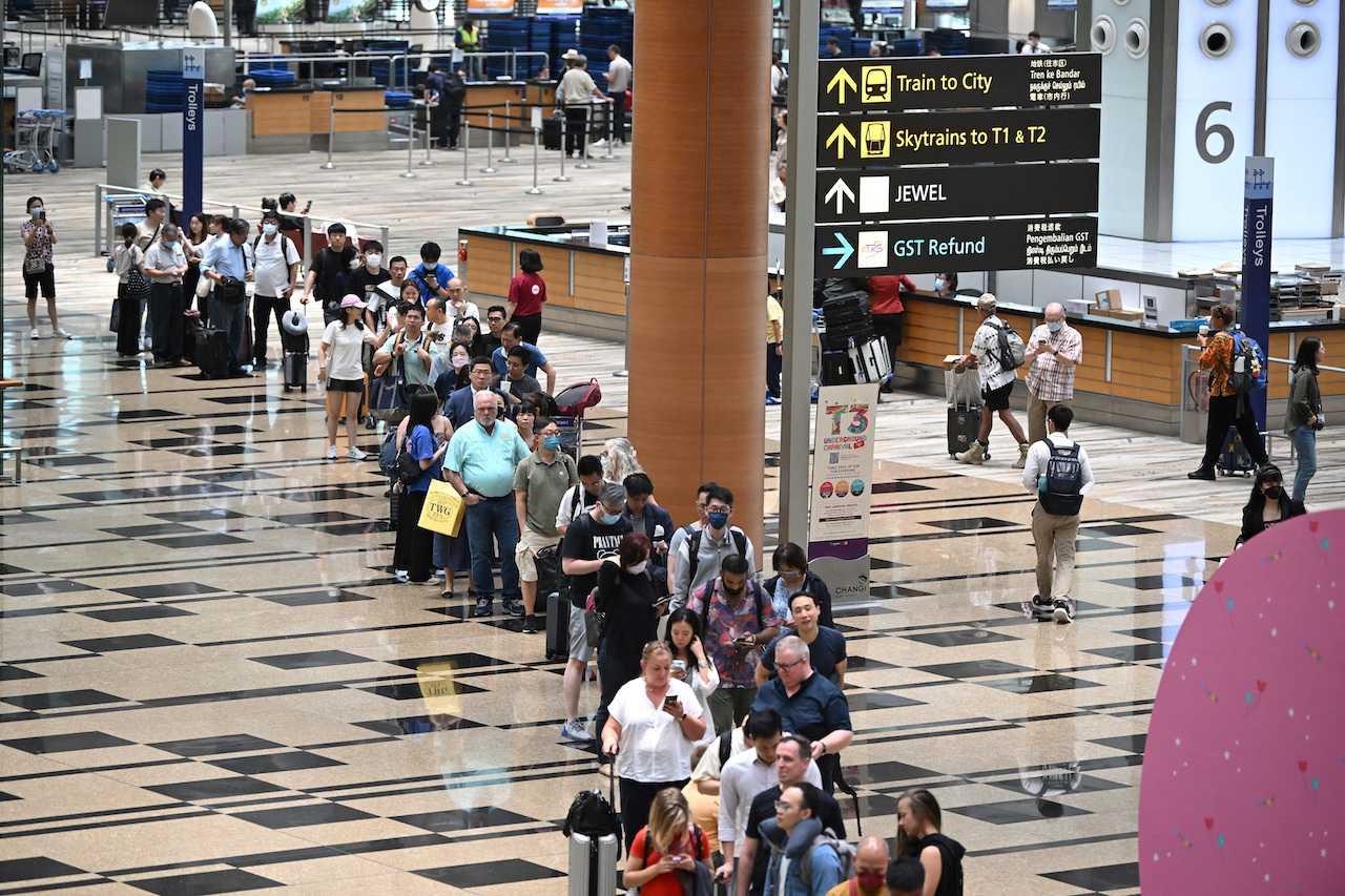 Passengers queue at the departure hall of Changi Airport Terminal 3 in Singapore, March 31. Photo: Reuters
