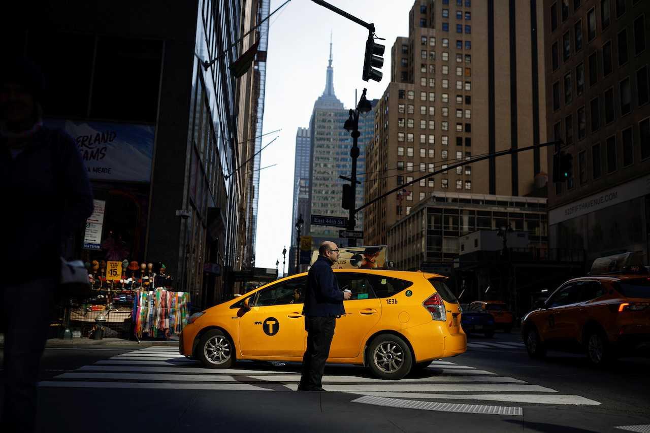 A man stands on the street as a taxi passes in Manhattan, in New York City, March 20. Photo: Reuters