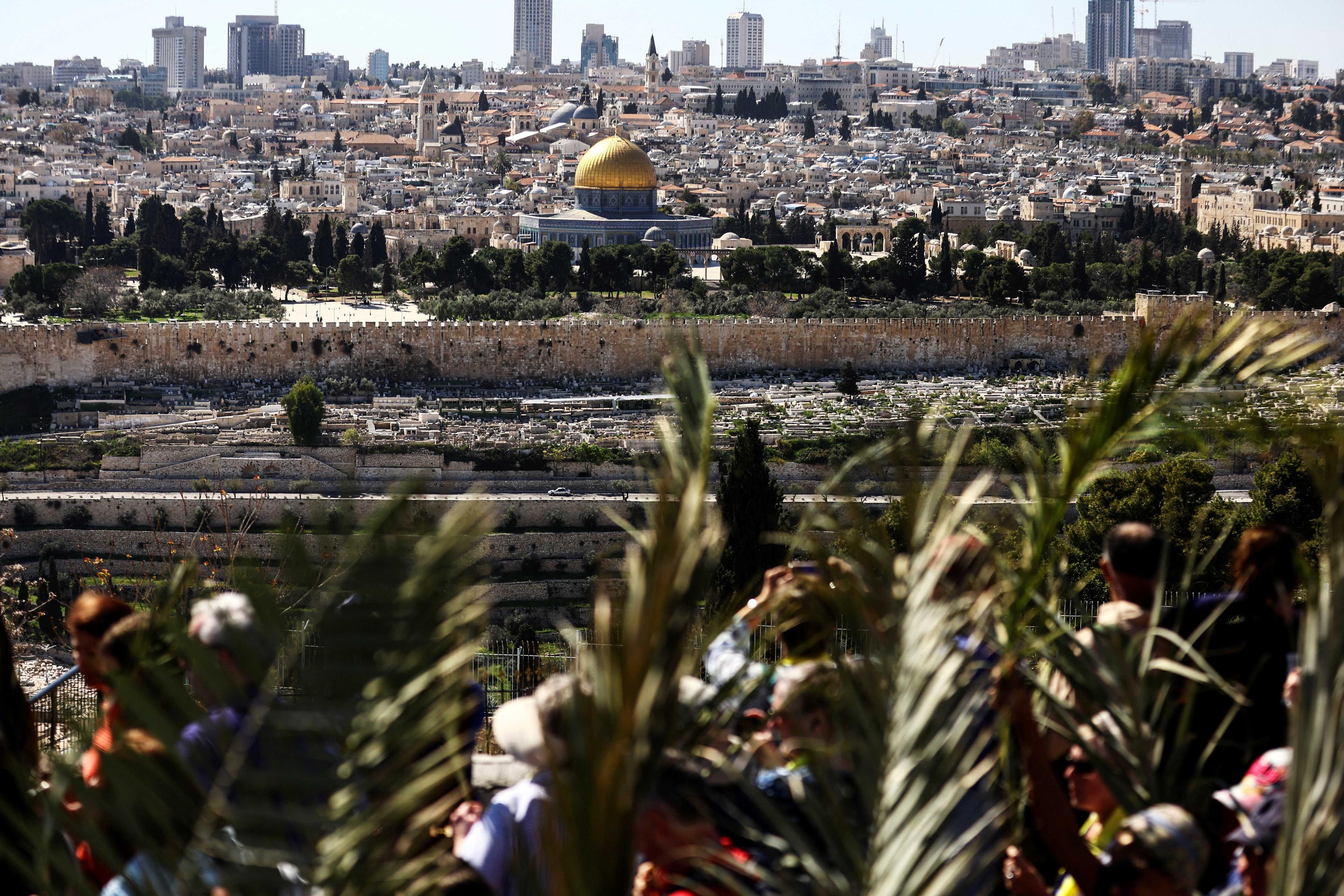The Dome of the Rock is seen in the background as Christian worshippers attend a Palm Sunday procession on the Mount of Olives in Jerusalem April 2. Photo: Reuters