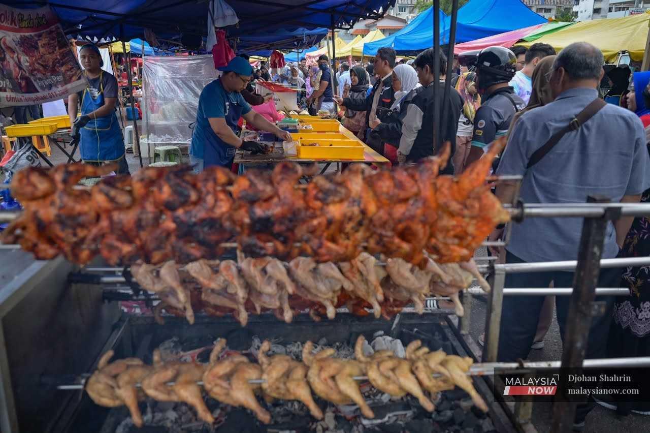 A vendor prepares barbecued chicken wings for sale at his stall in Bandar Baru Ampang, Kuala Lumpur.