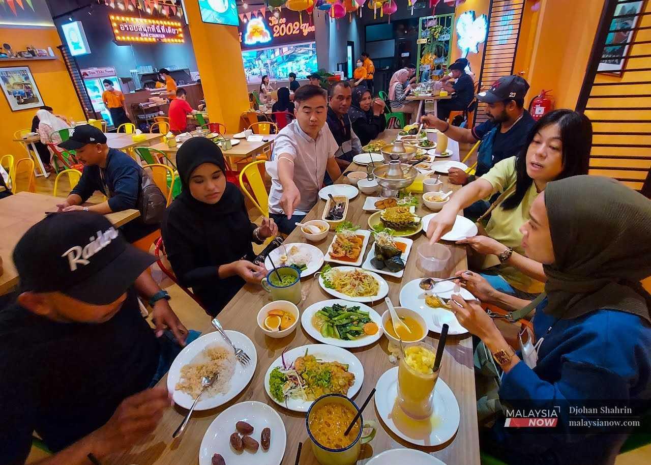 Chinese and Indians join their Malay friends in breaking their fast at a food court. 