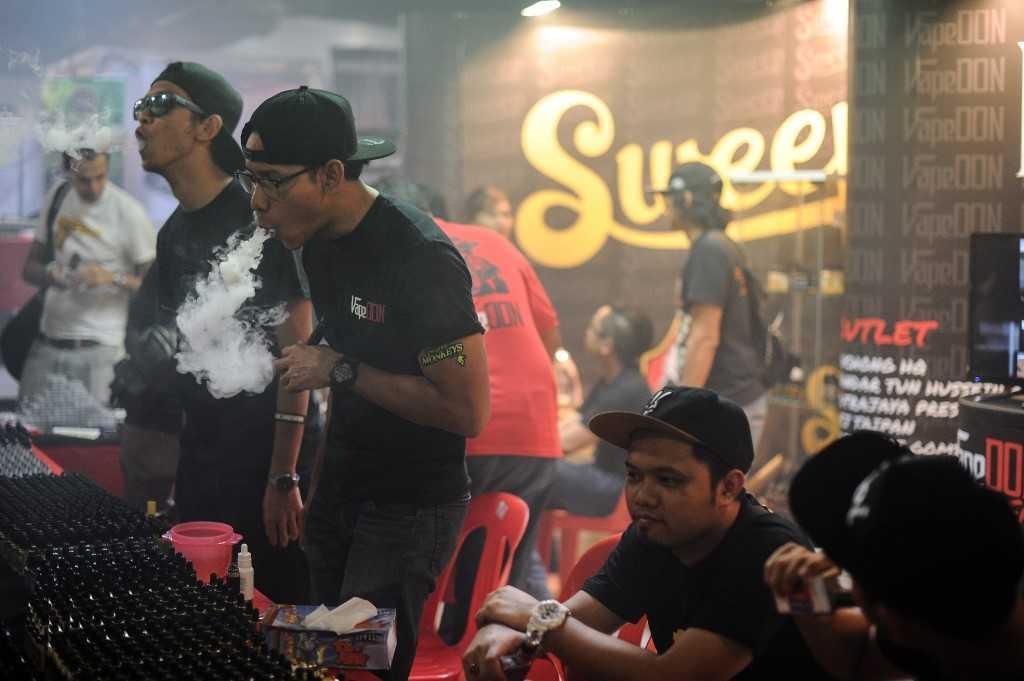 Promoters smoke e-cigarettes during a vape fair in Kuala Lumpur, Dec 5, 2015. Photo: AFP