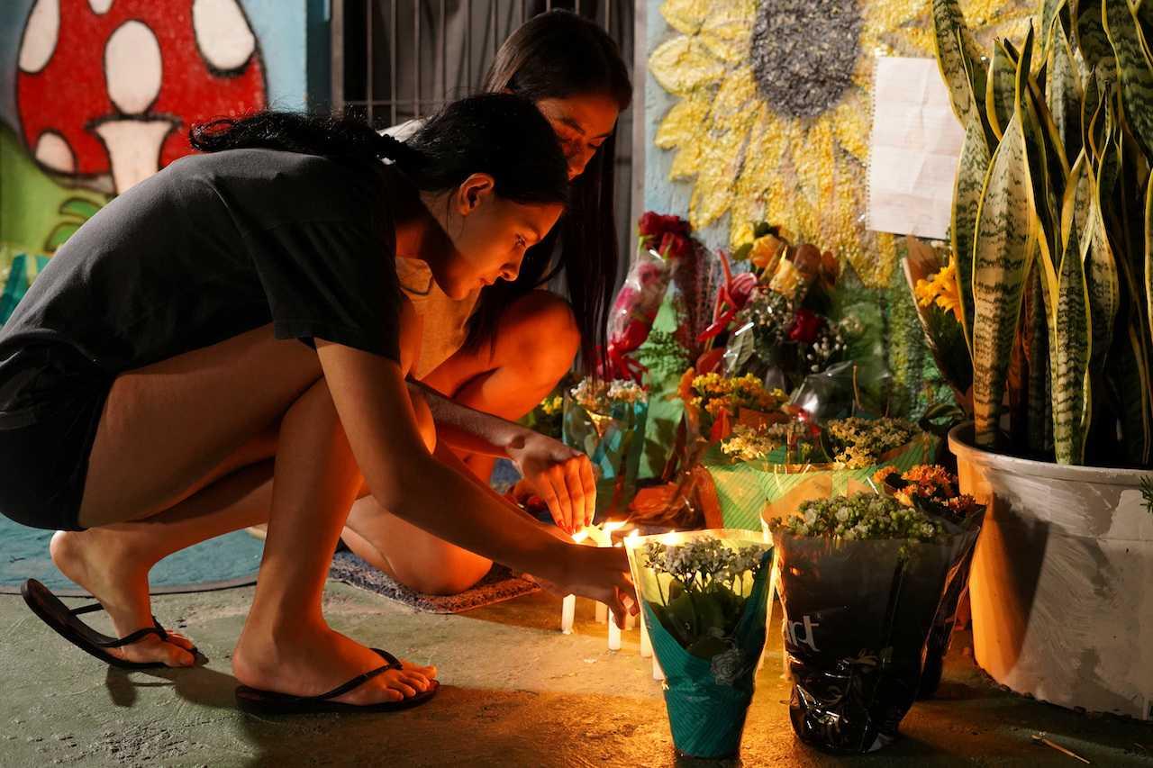 Wanita menyalakan lilin sewaktu majils penghormatan kepada mangsa serangan maut di Good Shepherd Center, di Blumenau, Santa Catarina, Brazil, 5 April. Gambar: Reuters