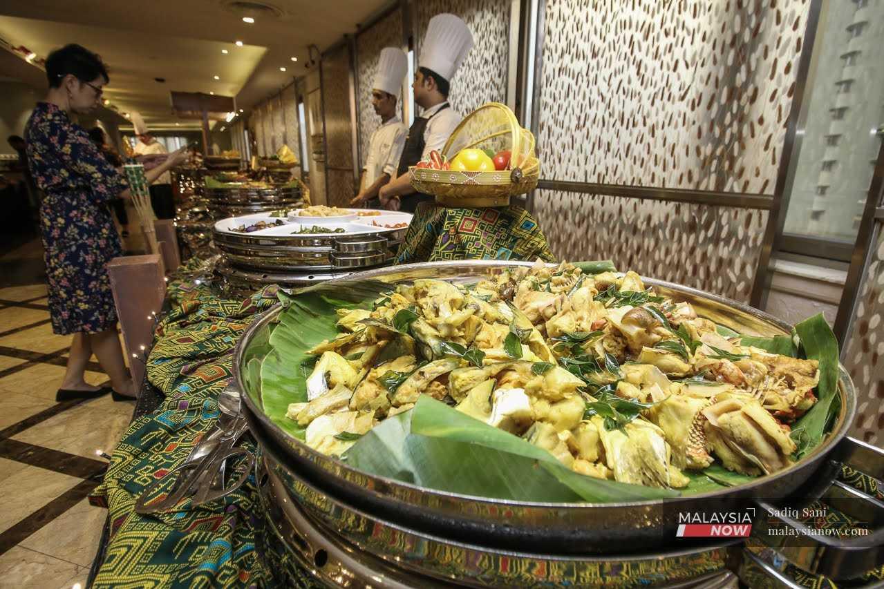 A woman chooses from an array of dishes at a Ramadan buffet at a hotel in Kuala Lumpur. 

