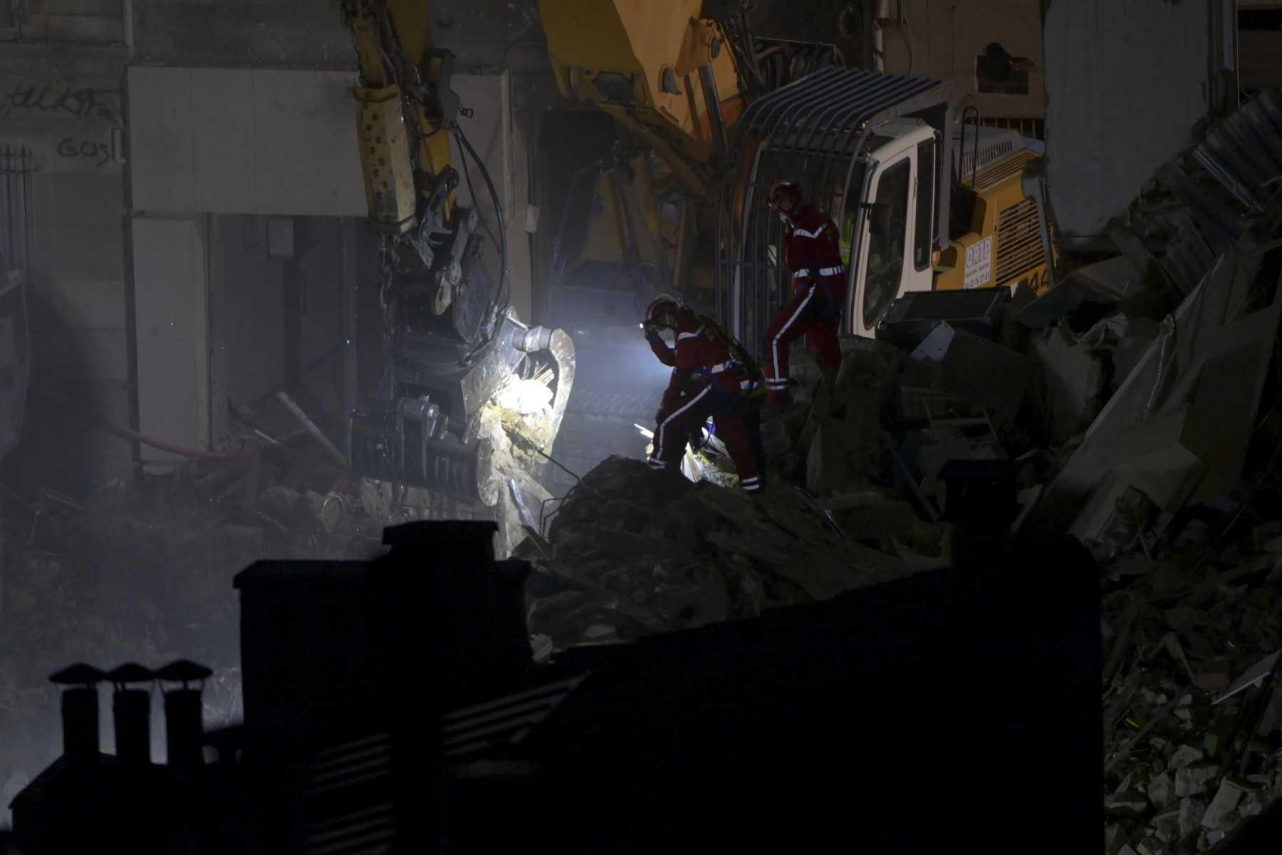 Emergency services workers look on as an excavator moves rubble at 'rue Tivoli' after a building collapsed in the street, in Marseille, southern France, on April 9. Photo: AFP 