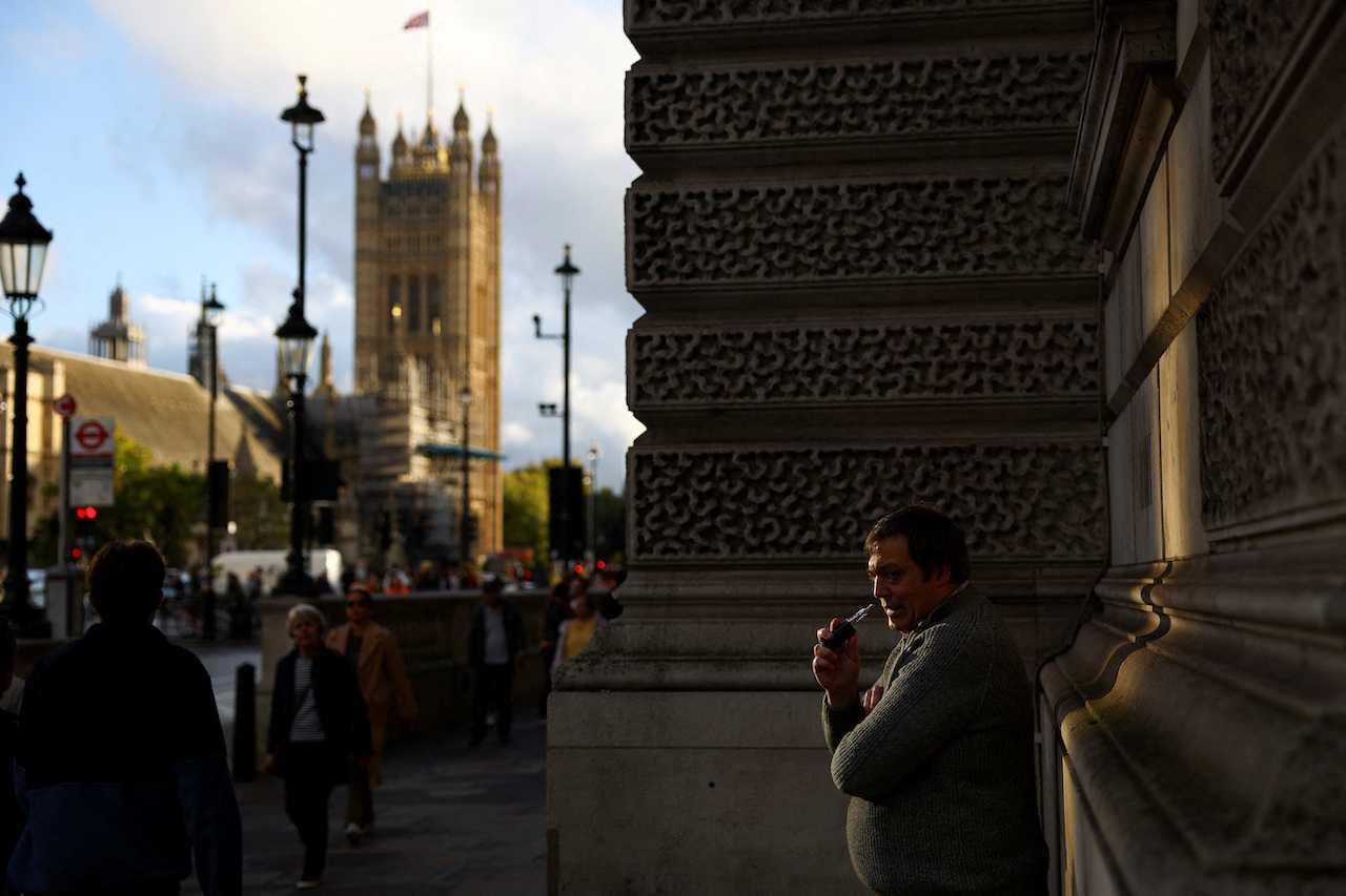 Seorang lelaki menghisap vape di luar Dewan Parlimen, di London, Britain, 20 Oktober 2022. Gambar: Reuters