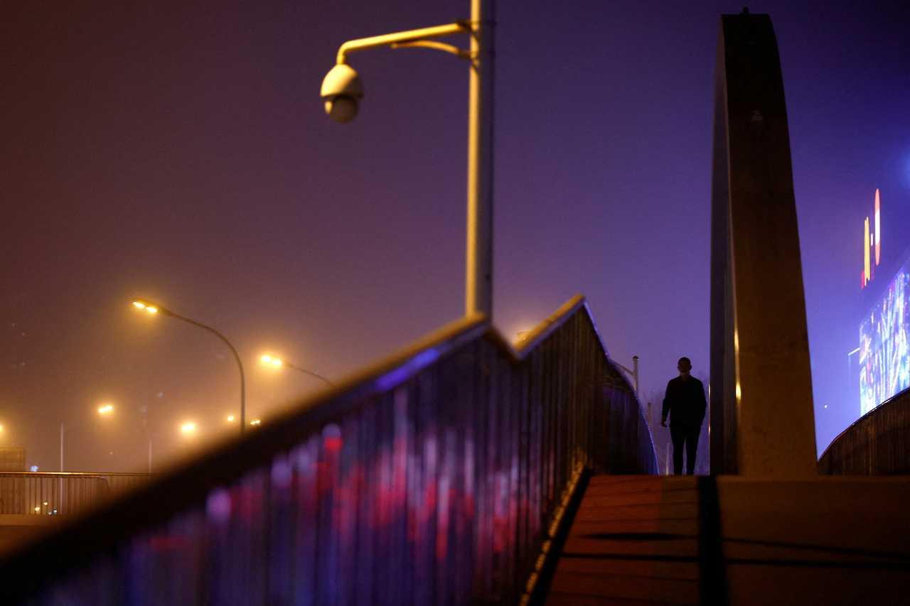 A man walks on an overpass amid a sandstorm as the city is shrouded in smog, in Beijing, China, April 10. Photo: Reuters