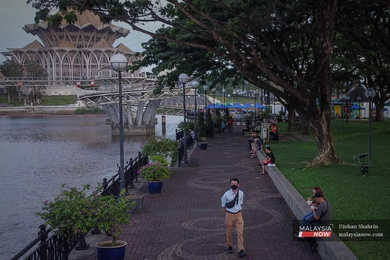 People stroll about at the Waterfront near the state legislative assembly building in Kuching, Sarawak. 

