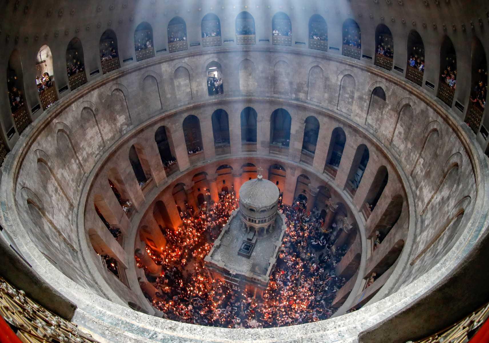 In this file photo taken on April 23, 2022, Orthodox Christians gather with lit candles around the Edicule, traditionally believed to be the burial site of Jesus Christ, during the Holy Fire ceremony at Jerusalem's Holy Sepulchre church. Photo: AFP