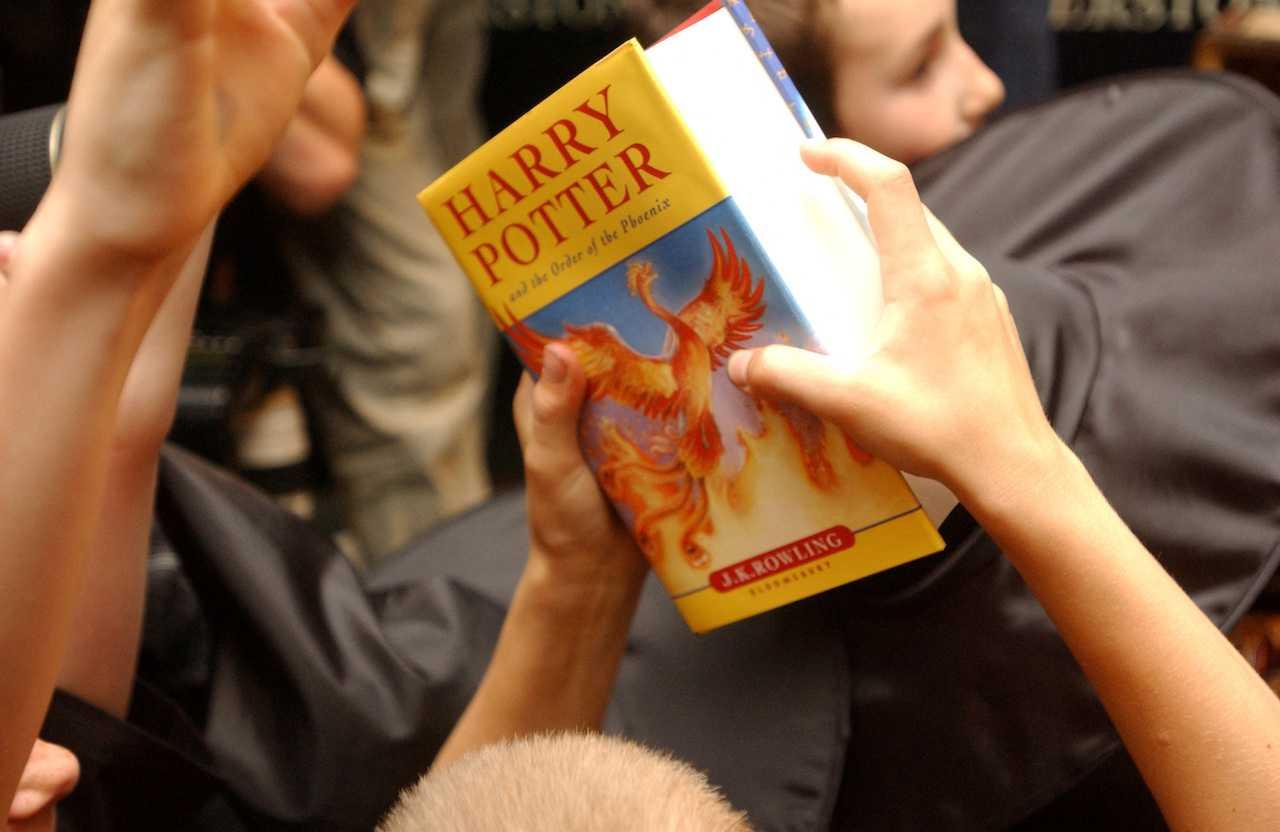 A child holds a copy of 'Harry Potter and the Order of the Phoenix' at a bookshop in central London, June 21, 2003. Photo: Reuters