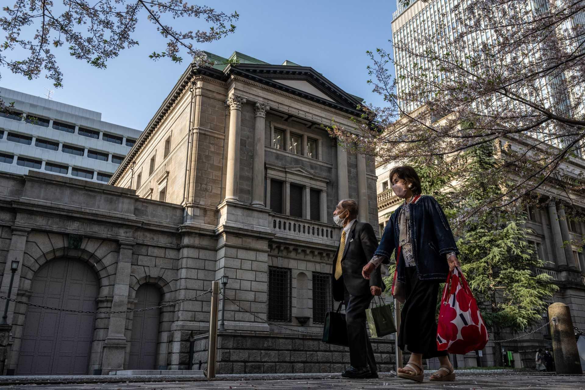 Pedestrians walk past the Bank of Japan headquarters in Tokyo on April 3. Photo: AFP
