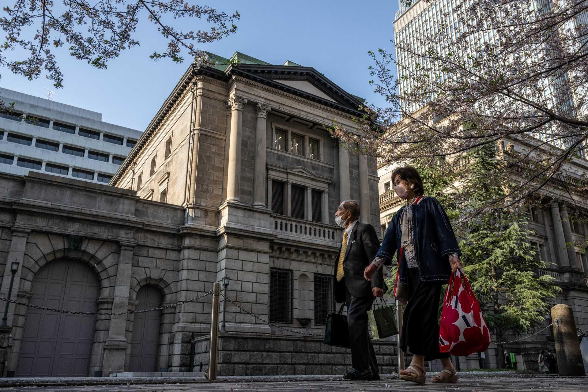 Pedestrians walk past the Bank of Japan headquarters in Tokyo on April 3. Photo: AFP 
