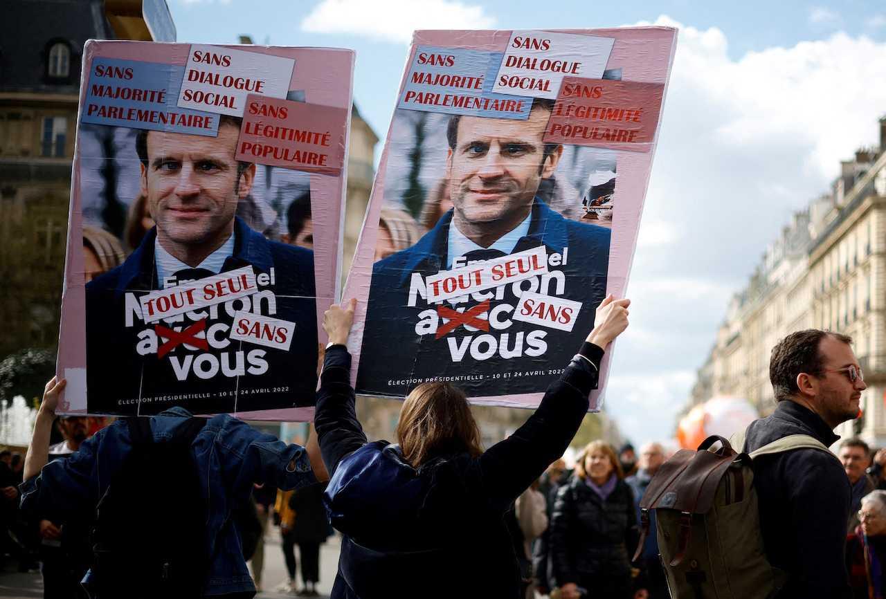 Protesters hold placards depicting French President Emmanuel Macron during a demonstration against the government's pension reform, in Paris, April 13. Photo: Reuters