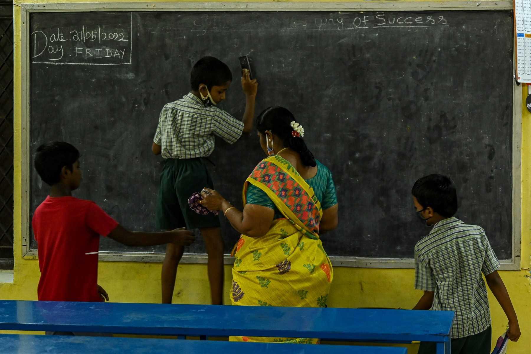 A student writes on the blackboard inside a classroom in Chennai on June 13, 2022. Photo: AFP