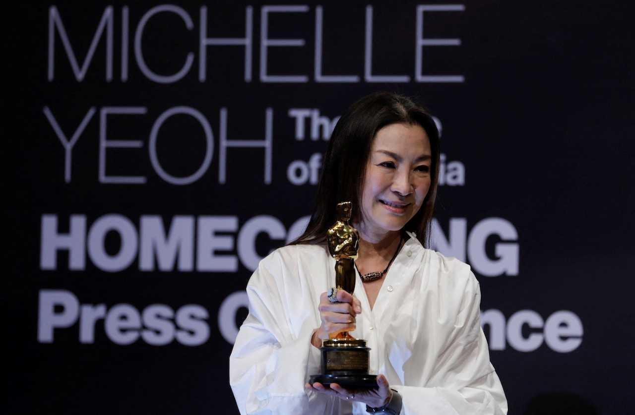 Actress Michelle Yeoh shows her engraved Oscar statuette during a news conference after returning to Malaysia for the first time since winning her Oscar for Best Lead Actress, at Kuala Lumpur, April 18. Photo: Reuters