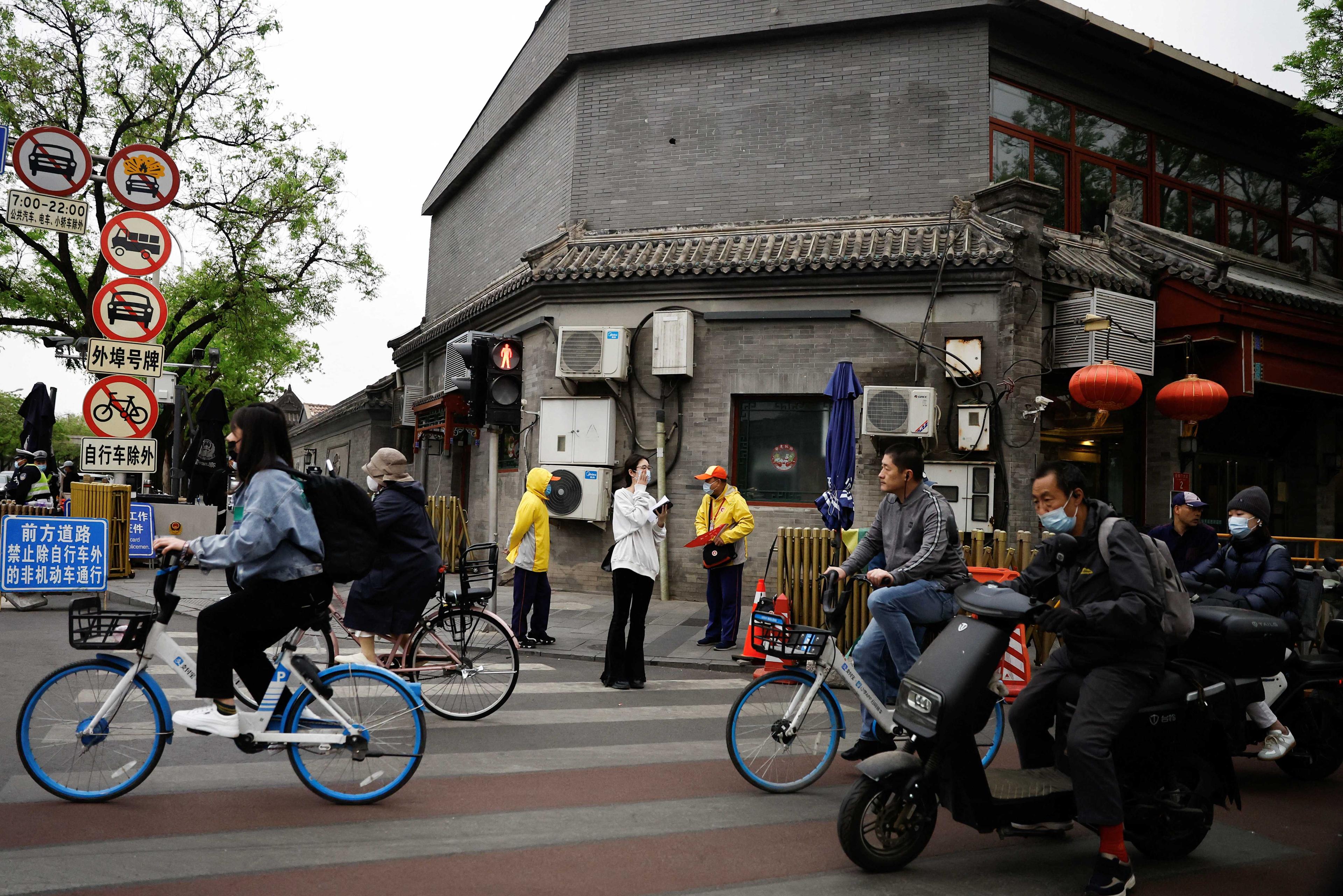 People ride bicycles and scooters on a street during morning rush hour, in Beijing, China April 20. Photo: Reuters