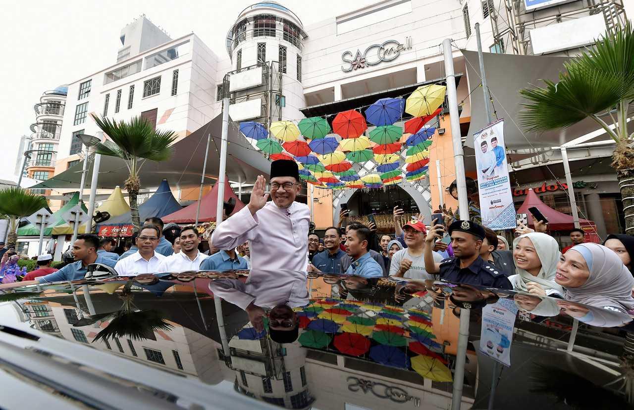 Prime Minister Anwar Ibrahim waves during a visit to the Ramadan bazaar at Kompleks PKNS in Section 14, Shah Alam, April 19. Photo: Bernama