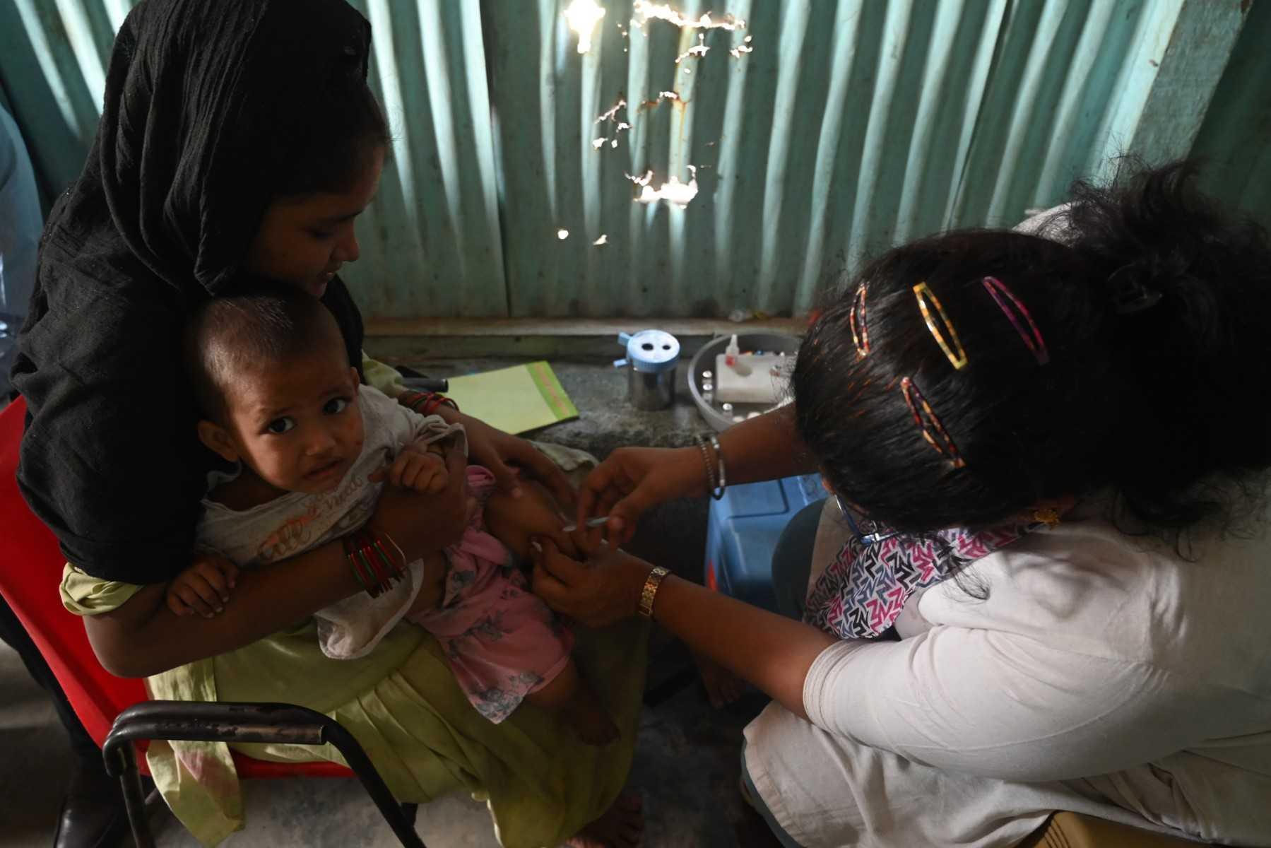 A health worker administers a vaccine to a child at a temporary vaccination camp following a measles outbreak that caused the death of 10 children, in Mumbai on Nov 23, 2022. Photo: AFP