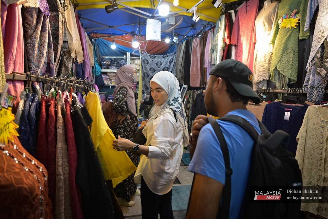 Customers look at new clothes for Hari Raya at the Aidilfitri bazaar in Jalan Tuanku Abdul Rahman, Kuala Lumpur. 
