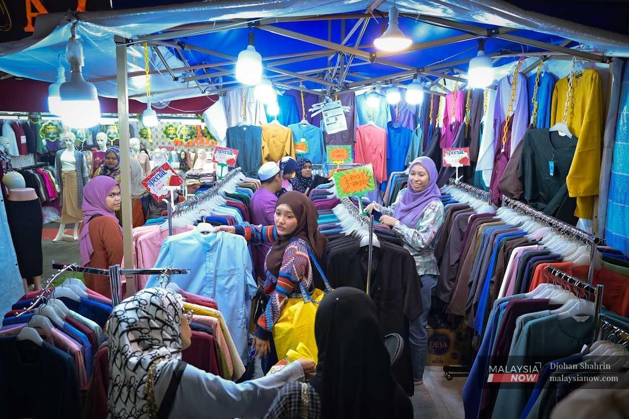 Beberapa pengunjung memilih baju yang dipamerkan diruang jualan semasa berkunjung ke Bazar Aidilfitri di Jalan Tuanku Abdul Rahman, 11 April.
