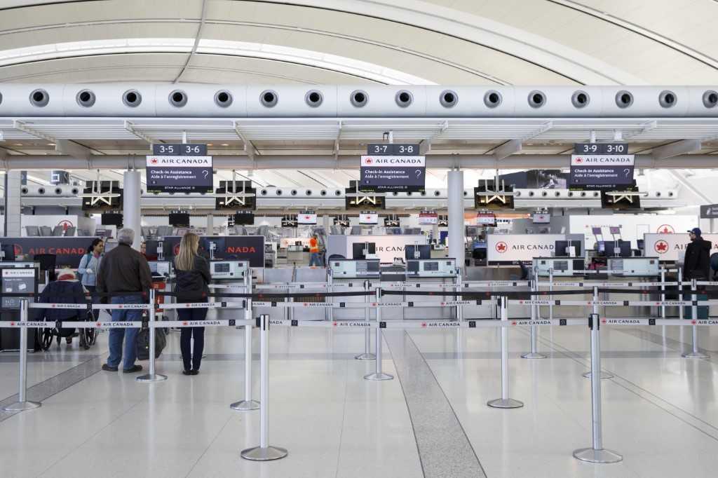 Passengers queue at the Air Canada check-in counter at Toronto Pearson International Airport on April 1, 2020 in Toronto, Canada. Photo: AFP